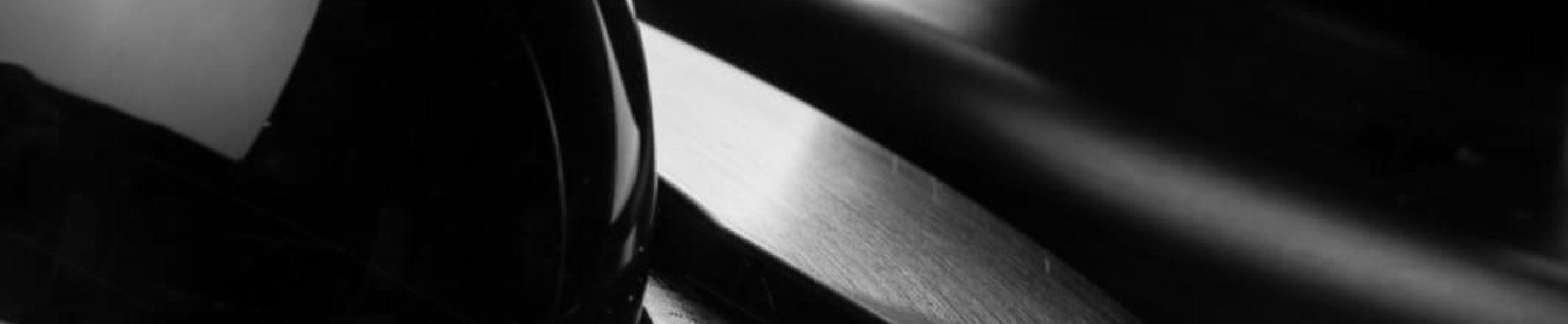 Closeup image of ice sphere in black aluminum ice press