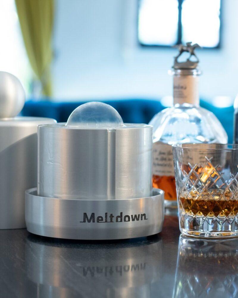 Meltdown aluminum Chubby ice press with clear ice sphere on countertop