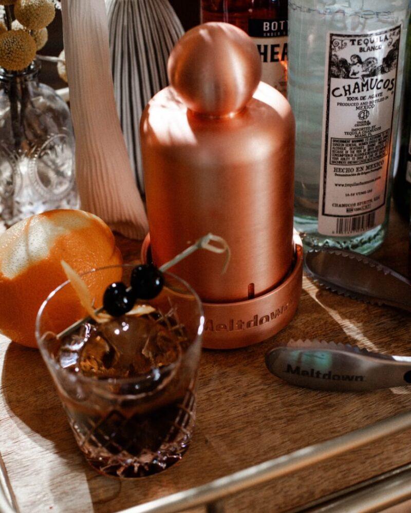 Meltdown Mini Mogul sitting on bar cart next to Negroni glass with clear ice sphere
