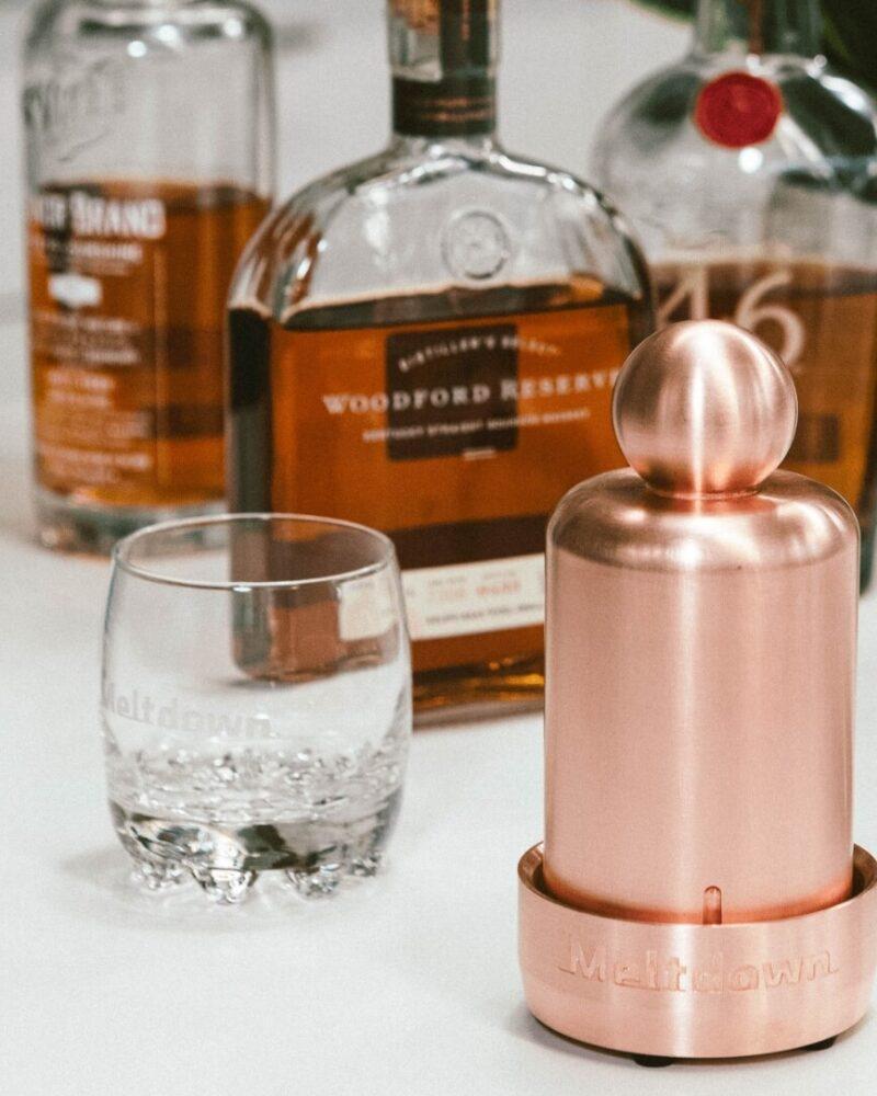 Meltdown Mini Mogul copper ice press on countertop with Woodford Reserve and Meltdown glass