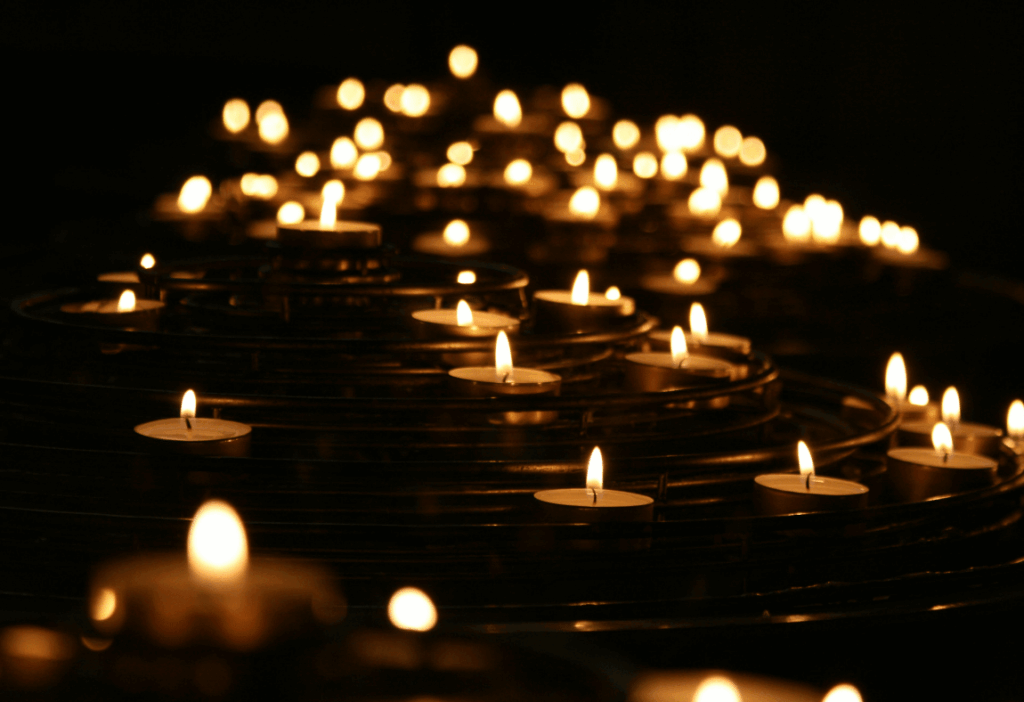Multiple small candles are arranged in concentric circles, each casting a warm, soft light that transforms the darkness into a serene and peaceful party atmosphere.